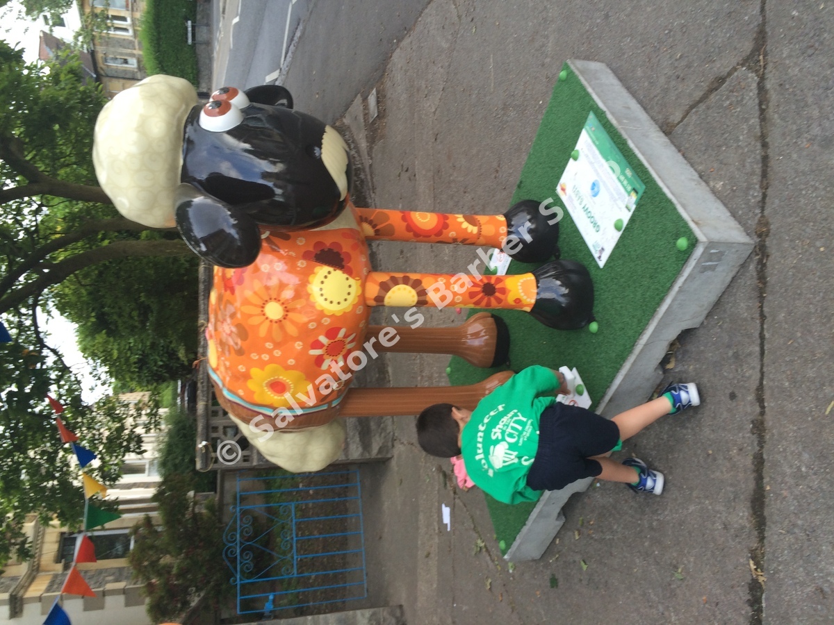 Young volunteer cleaning Groovy Baby! Shaun the Sheep sculpture